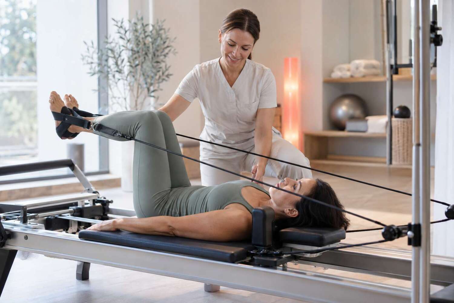 Professionista che assiste una cliente durante il Pilates Reformer con infrarossi